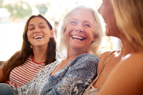 Image Text: 500x332_0024_Mother With Adult Daughter And Teenage Granddaughter Relaxing On Sofa And Talking At Home