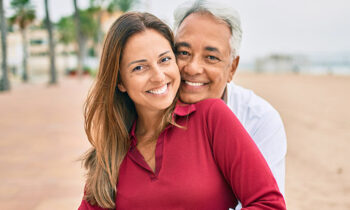 Image Text: 690x460-Middle age hispanic couple smiling happy and hugging sitting on the bench.